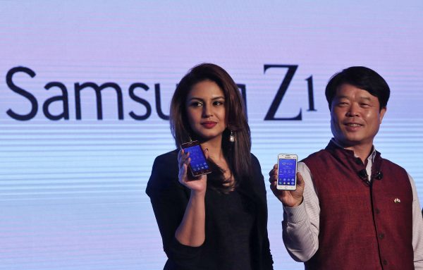 Hyun Chil Hong, president and chief executive of Samsung India Electronics, and Bollywood actress Qureshi hold the Samsungs new Z1 smartphones at its launch in New Delhi